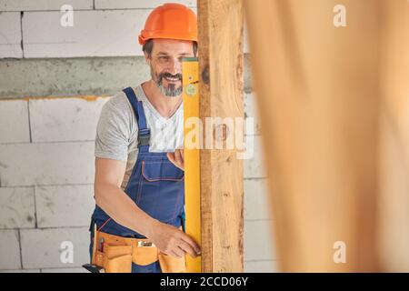 Smiling male worker using a construction tool Stock Photo