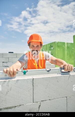 Man with hands on a spirit level looking ahead Stock Photo