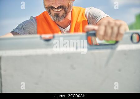 Smiling constructor worker using a spirit level Stock Photo