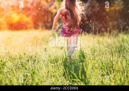 Large group of kids, friends boys and girls running in the park on sunny summer day in casual clothes . Stock Photo