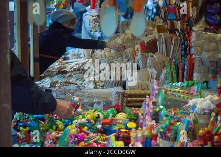 Krakow, Poland - December 16, 2014: A girl shopping colorful decorative items / souvenir during christmas eve in a city center main square Stock Photo