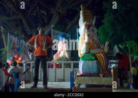 Bangalore, India - September 07, 2016: A man stand next to Ganesha god statue ( big sculpture ) for immersion purposes at the end of Ganesha chaturthi Stock Photo