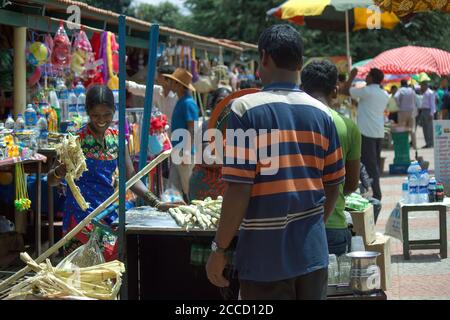 Bangalore, India - September 18, 2016: A female seller of sugarcane juice serving fresh juice to customer in a market place located in Karnataka state Stock Photo