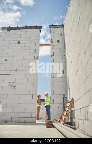 Man with a roll of paper shaking a woman hand Stock Photo