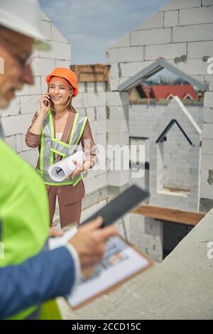 Two civil engineers using their gadgets outdoors Stock Photo