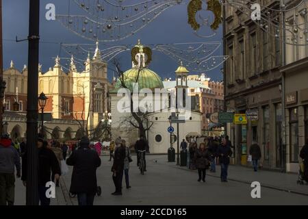 Krakow, India - December 23, 2014: Decorated street during Christmas decoration at city center main square with tourists Stock Photo