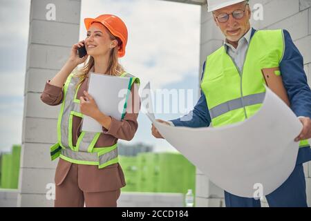 Smiling senior male engineer analyzing technical drawings Stock Photo