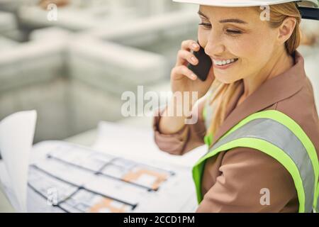 Attractive female engineer using her cellphone outdoors Stock Photo