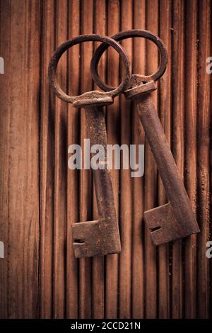 Two vintage keys on wooden background. Top view. Stock Photo