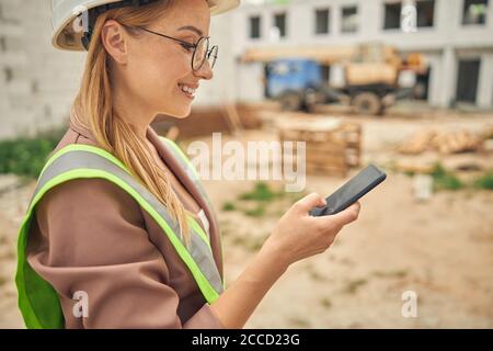 Contented young woman using her gadget outdoors Stock Photo