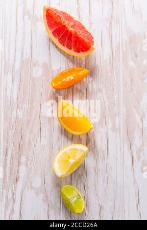 Slices of citrus fruits on wooden background. Preparing lemonade, ice tea or summer drink. Stock Photo