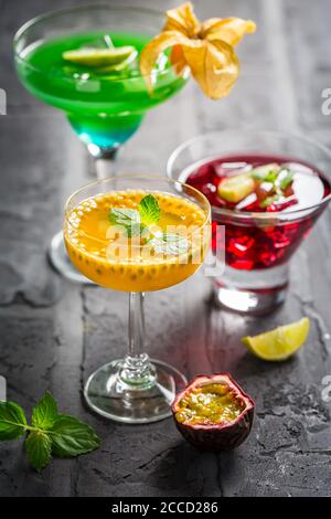 Assortment of different cocktails with fresh fruits, ice and mint on black background. Stock Photo