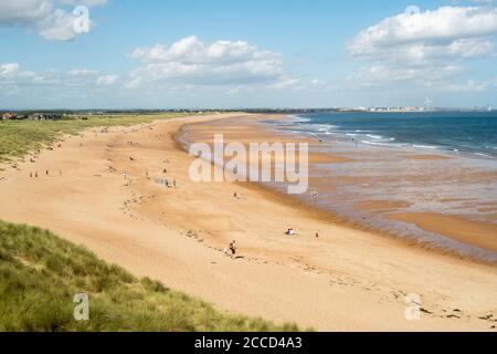 People enjoying summer sunshine on the beach north of Seaton Sluice, Northumberland, England, UK Stock Photo