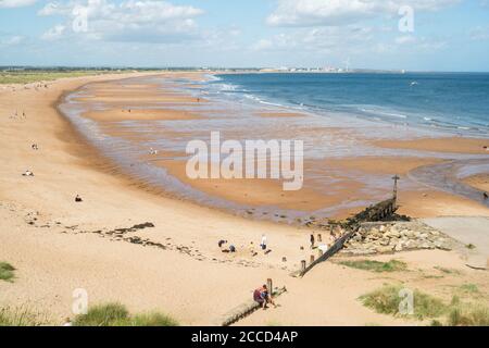 People enjoying summer sunshine on the beach north of Seaton Sluice, Northumberland, England, UK Stock Photo