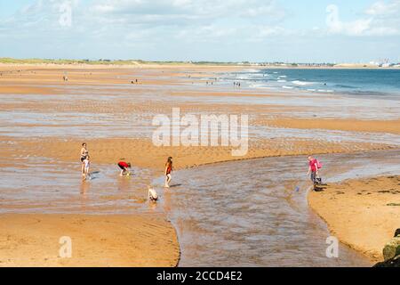 Family on the beach at Seaton Sluice, Northumberland, England, UK Stock Photo