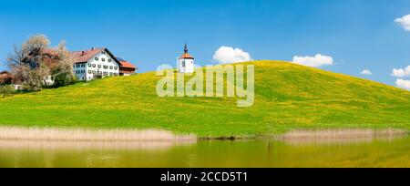 Panorama von Blumenwiese mit Bauernhof und Kapelle Stock Photo