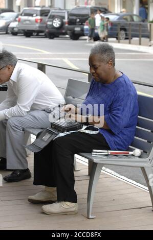 Austin, TX  USA, April 23, 2007: An African-American shopper types on her 'BrailleNote' machine, similar to a Personal Digital Assistant (PDA) for blind people, at an upscale shopping center in Austin. ©Bob Daemmrich Stock Photo