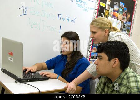 Donna, TX  March 1, 2007: Female teacher helps students in social studies class working on essays at the IDEA Public School, a seven-year old charter school with 1,200 mostly Hispanic students in south Texas. ©Bob Daemmrich Stock Photo