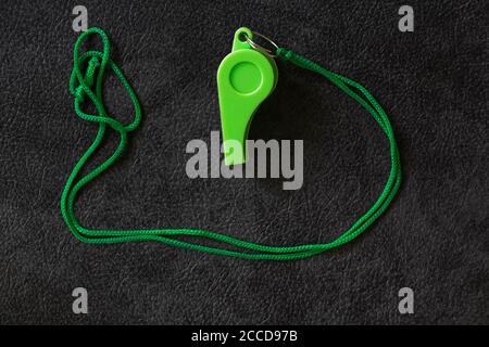 Green whistle of a sport referee or trainer on black background, free copy space Stock Photo