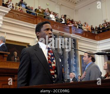 Austin, TX January 10, 2007: Young black man sings the United States' national anthem on opening day of the 80th session of the Texas Legislature in the House of Representatives.  ©Bob Daemmrich Stock Photo