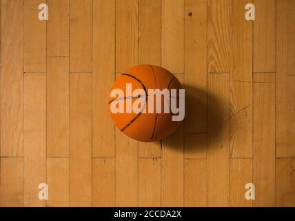 Old basketball ball on a basketball court, hardwood floor Stock Photo