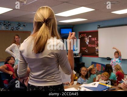 Round Rock, TX  September 28, 2006: Fourth grade teacher works with students on math lesson at suburban Austin elementary school.  ©Bob Daemmrich Stock Photo