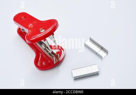 red staple remover and refill on white table Stock Photo