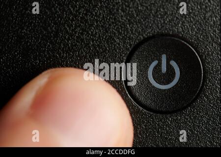 Pushing power on off black button macro close up view Stock Photo