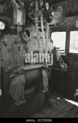 Huge vintage steam locomotive interior, black and red painted steel train. Coal-powered steam express on tracks. Inside view of power parts of machine Stock Photo