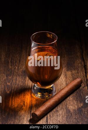 Single malt scotch whiskey in glencairn glass with cuban cigar on wooden table background. Top view Stock Photo