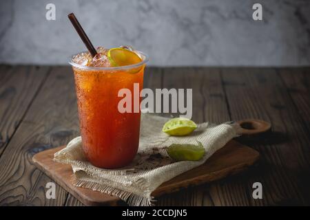 ice tea with slice of lemon in plastic cup on the wooden  background Stock Photo