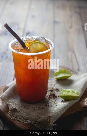 https://l450v.alamy.com/450v/2ccdjn9/ice-tea-with-slice-of-lemon-in-plastic-cup-on-the-wooden-background-2ccdjn9.jpg