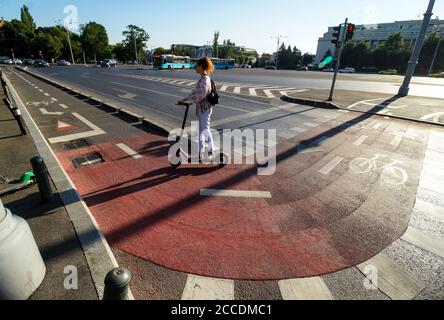 Bucharest, Romania - August 10, 2020: People ride electric scooter on the Victory Avenue bicycle track in Bucharest, Romania. Stock Photo