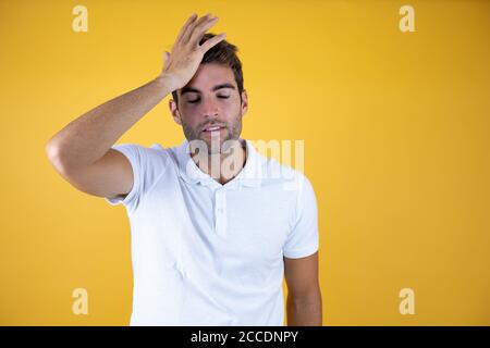 Young handsome man putting one hand on her head smiling like he had forgotten something standing on pink background. Stock Photo