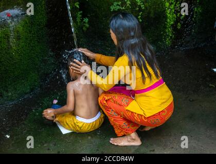 The Melukat ceremony is a purification ceremony to cleanse the body both spiritually and physically by washing or dowsing the head and body in holy wa Stock Photo