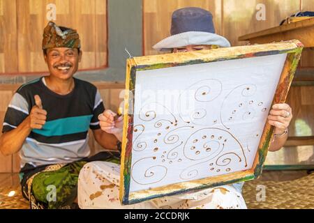 Batik is an traditional Balinese art technique of wax-resist dyeing applied to whole cloth. This technique originated from Java but has become popular Stock Photo