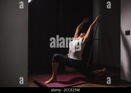 young caucasian sporty fitness woman doing exercises, stretching at home, attractive lady in sport clothes leads healthy lifestyle, she throws head an Stock Photo