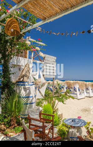 Straw beach umbrellas and sun chairs on a sandy beach on the east coast of Zakynthos island in Greece Stock Photo