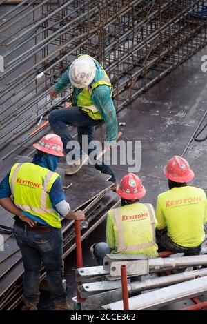 Austin, TX USA July 25, 2020: Concrete crews take a break after working on the parking garage of a 53-story building during a night-time pour in the downtown Austin, TX. Huge construction projects continue unabated in Texas despite the nationwide COVID-19 pandemic and the state stricken with over a half million cases and 10,000-plus deaths. Stock Photo