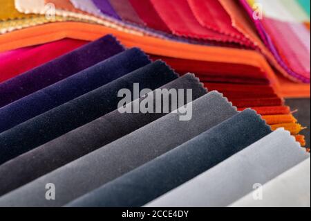 Gradient colored luxury velvet samples folded in rows and placed in a pile on a table Stock Photo