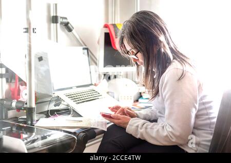 caucasian lady, in home working office desk, with documents, laptop, smartphone, ecc… Stock Photo
