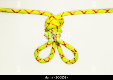 double figure eight 8 knot or Flemish loop or bunny ears use for climbing or equalizing anchors in alpinistic. Stretched colored, green rope for Stock Photo