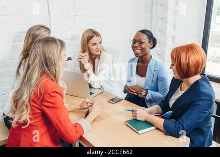 Young mixed race women team up with freelance friends and create a small coworking club that can eventually grow into a small firm. Stock Photo