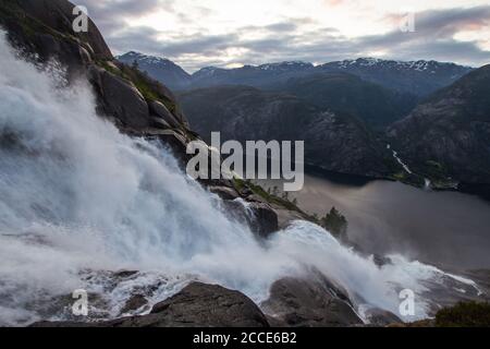 Cascading waterfall Langfossen in Summer sunny day. Beautiful view on Lysefjorden fjord from slope mountain near source River Vaulaelva. Haugesund Stock Photo
