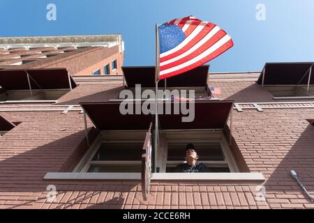 Tulsa, OK, USA. 20th Jun 2020. A man watches over a crowd of Trump supporters and protesters near an entrance to the President Donald Trump rally close to the BOK center. Stock Photo