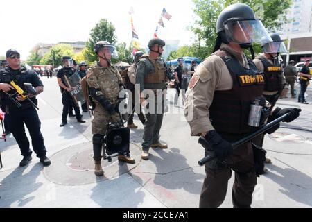 Tulsa, OK, USA. 20th Jun 2020. Police officers and National Guard stand by and block protesters from approaching an entrance to a President Donald Trump rally.