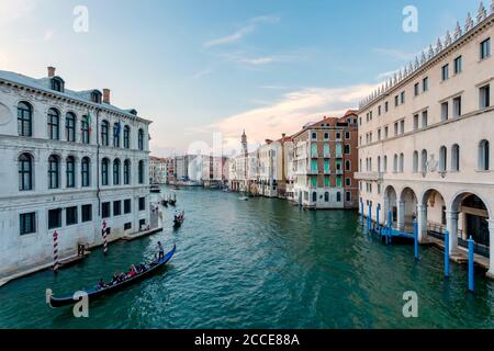 Venice Grand Canal with gondolas sailing with tourists visiting the city. The natural light of the late afternoon is reflected on the building facades Stock Photo