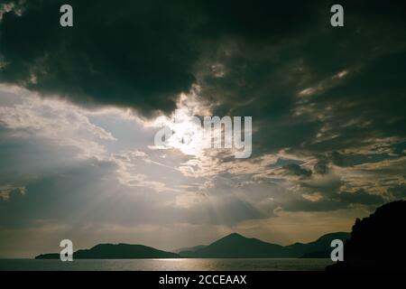 A gloomy sky with clouds over the mountains and the sea. Stock Photo