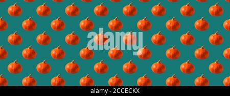 Seamless pattern made with an orange pumpkin on a blue background. Stock Photo