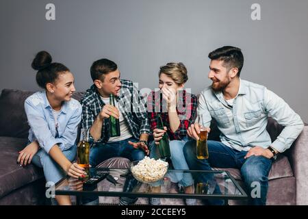 young gorgeous people are telling jokes while sitting on the sofa indoors. close up shot Stock Photo